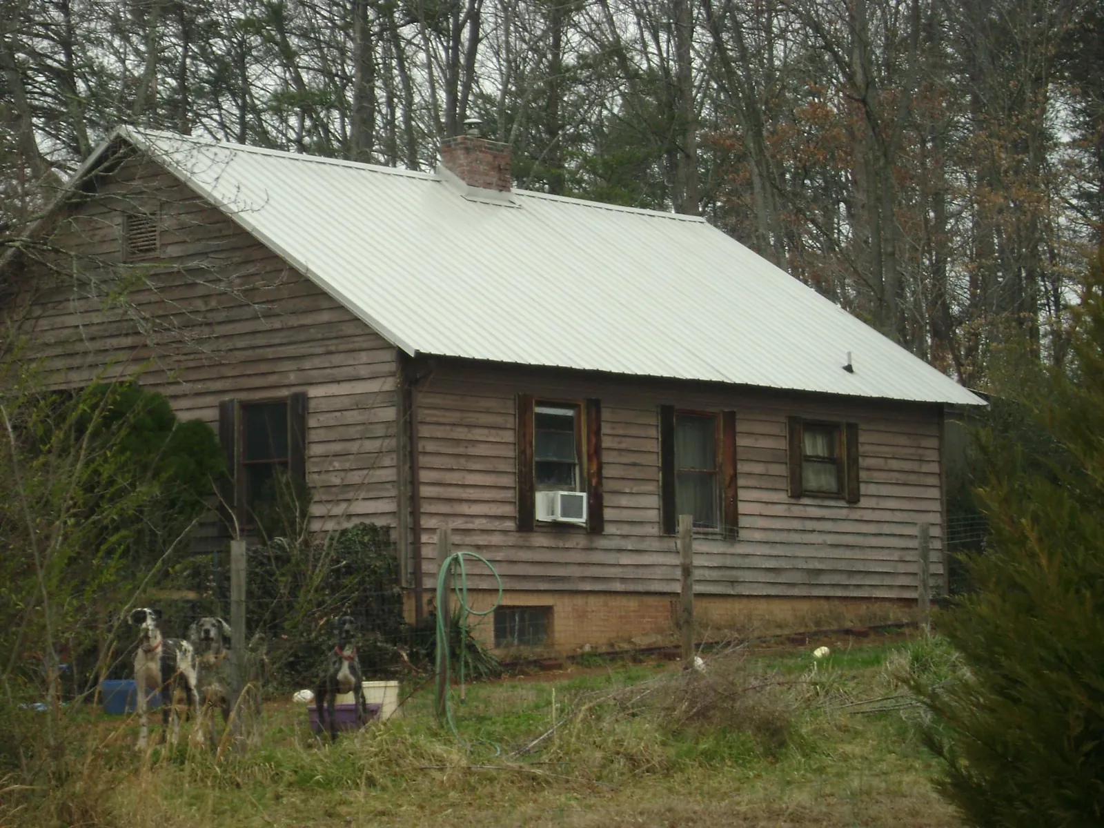 White metal roof on an old wood sided farmhouse, from a Metal Roof Installation job in Fishtail